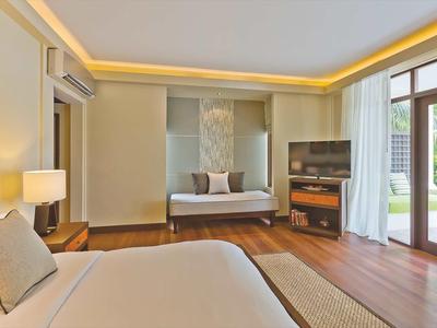 Helles Schlafzimmer mit modernem Bett, Holzfußboden und großem Fenster zum Garten.