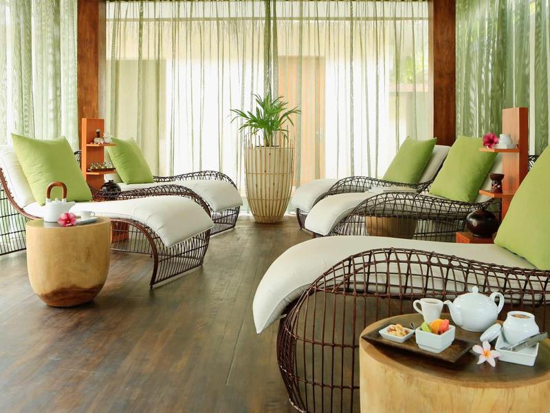 Cozy relaxation room with loungers, green cushions, and decor in a wellness hotel.