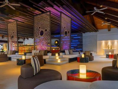 Espace lounge d'hôtel moderne avec éclairage coloré et sièges confortables