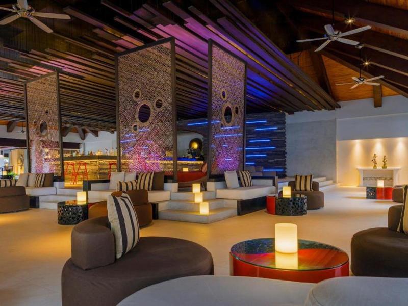 Espace lounge d'hôtel moderne avec éclairage coloré et sièges confortables