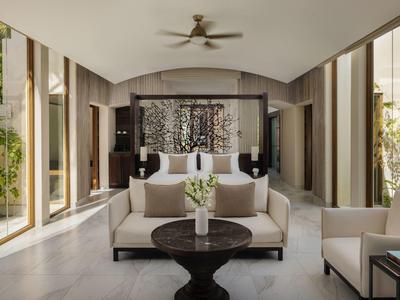 Modern eingerichtetes Wohnzimmer mit großen Fenstern, Sofas und einem Deckenventilator.