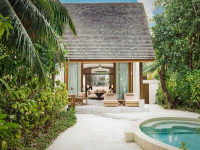 Luxuriöse Villa mit privatem Pool, umgeben von tropischer Vegetation und offenem Wohnbereich.