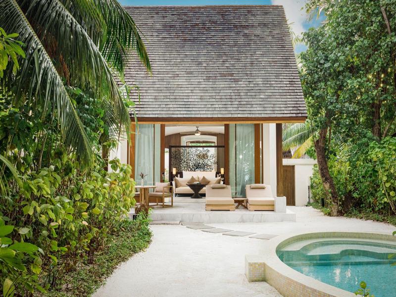 Luxuriöse Villa mit privatem Pool, umgeben von tropischer Vegetation und offenem Wohnbereich.