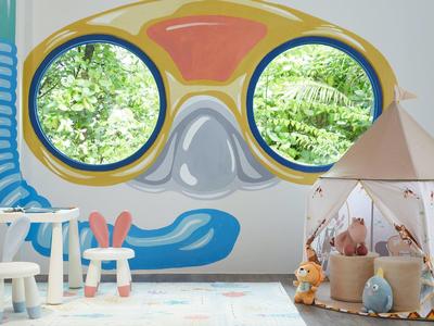 Sala giochi per bambini con parete a tema oceano e tenda bianca con giocattoli