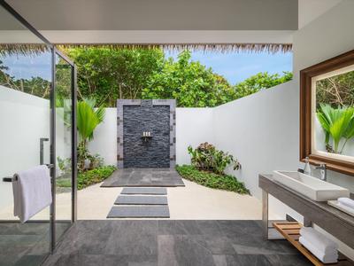 Area esterna moderna con doccia libera, pavimento in pietra naturale e grandi specchi accanto al lavandino.