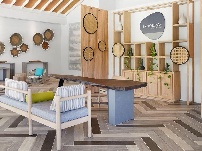 Interno moderno della hall dell'hotel con posti a sedere e cesti da parete decorativi.