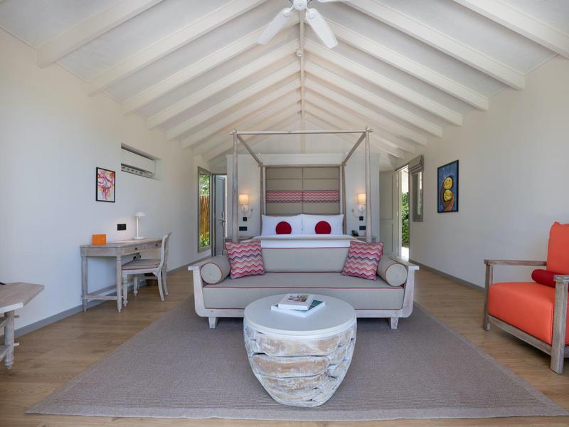 Habitación luminosa con cama cómoda, sofá, sillones y escritorio, ideal para huéspedes del hotel.