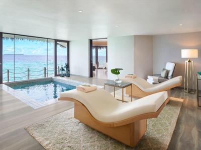 Habitación de hotel moderna con jacuzzi privado y vistas al mar a través de grandes ventanas