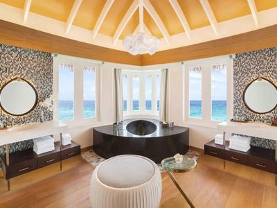 Baño lujoso con bañera independiente, azulejos de mosaico y vista al mar.