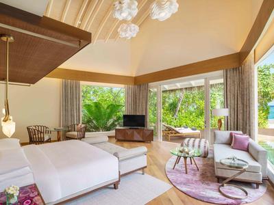 Habitación de hotel moderna con cama grande, terraza y vista a la piscina y jardín.