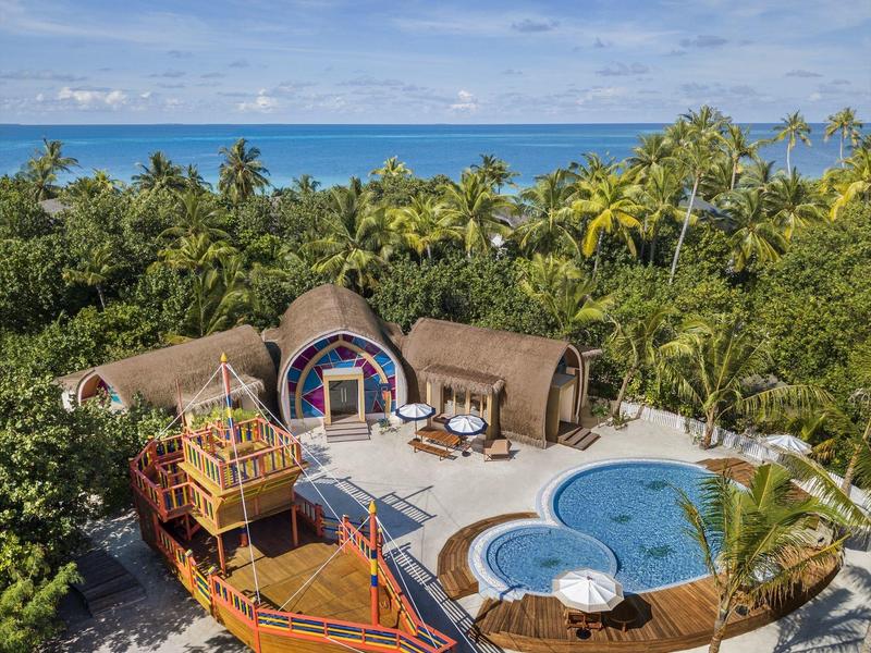 Lodge exótica con dos cabañas redondas, piscina y vista al mar rodeada de palmeras.