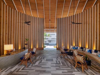 Hall d'hôtel spacieux avec boiseries, sièges modernes et éclairage chaleureux