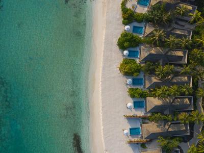 Vogelperspektive eines tropischen Resorts mit Strand, Liegen und klarem blaugrünem Wasser