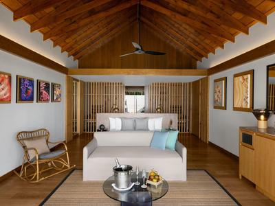 Chambre d'hôtel élégante avec plafond en bois, lit et décoration moderne.