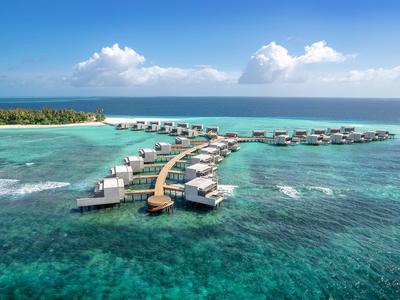 Luxurious overwater bungalows at a resort with clear blue water and blue sky