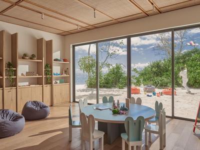 Jasne pomieszczenie dla grup z niskimi stołami, wygodnymi pufami i dużym oknem widokowym.