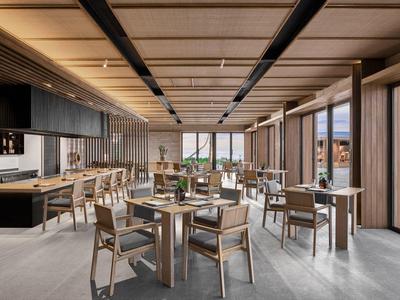 Nowoczesna restauracja z elementami drewnianymi, dużymi oknami i widokiem na morze.