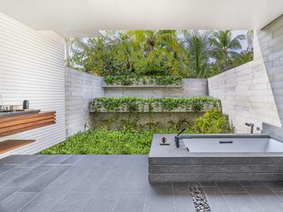 Nowoczesna przestrzeń na zewnątrz z tarasem, wanną i zieloną ścianą roślin