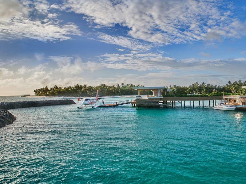 Przejrzysta turkusowa woda z wodnosamolotami przy tropikalnym pomoście pod niebieskim niebem