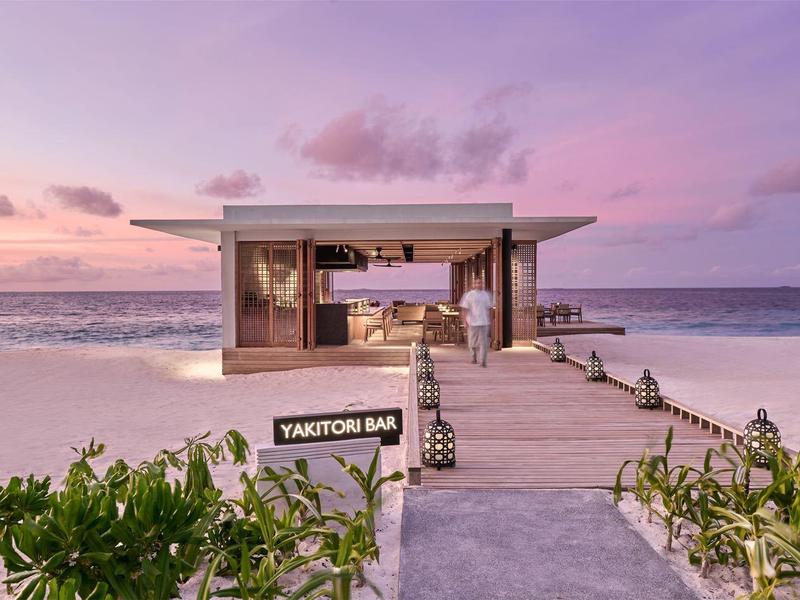 Nowoczesna, otwarta restauracja na plaży o zachodzie słońca z widokiem na ocean