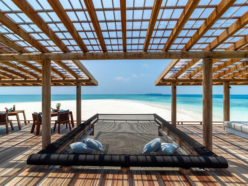 Otwarta strefa wypoczynkowa z widokiem na plażę i morze przy czystym niebie.