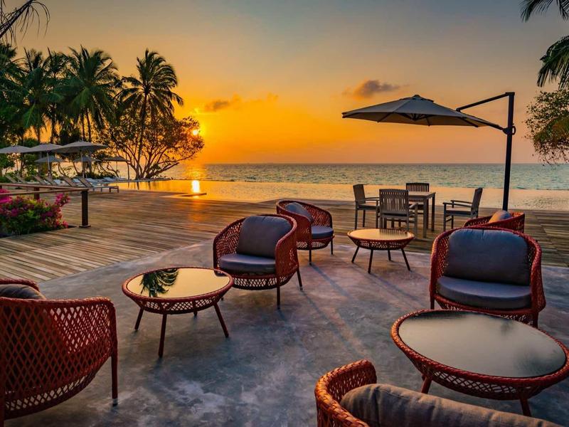 Terrace with seating and view of sunset over the sea