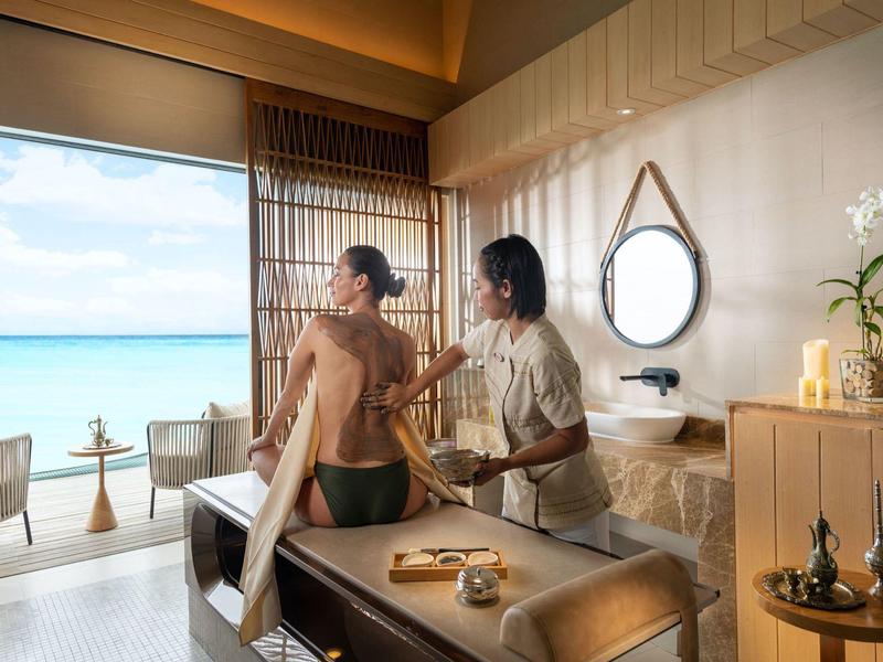 Moment spa relaxant avec massage dans une pièce avec vue sur la mer.