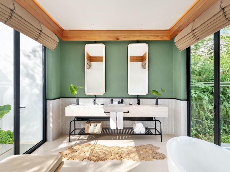 Salle de bain moderne avec deux lavabos, grands miroirs et beaucoup de lumière naturelle.