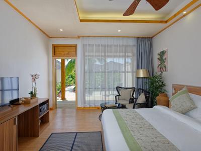 Chambre d'hôtel lumineuse avec lit double, meubles en bois et vue sur une terrasse.