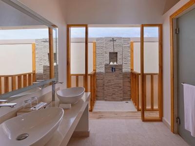 Salle de bain moderne avec deux vasques et douche indépendante encadrée de bois.
