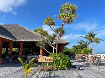 Restaurant ouvert au toit de chaume avec panneaux et cadre tropical en bord de plage