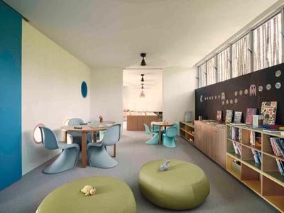 Modern, colorful room with bean bags, chairs, and shelves, ideal for leisure or relaxation.