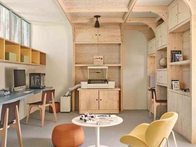 Bright, modern office with wooden furniture, two chairs, and natural light from large windows.