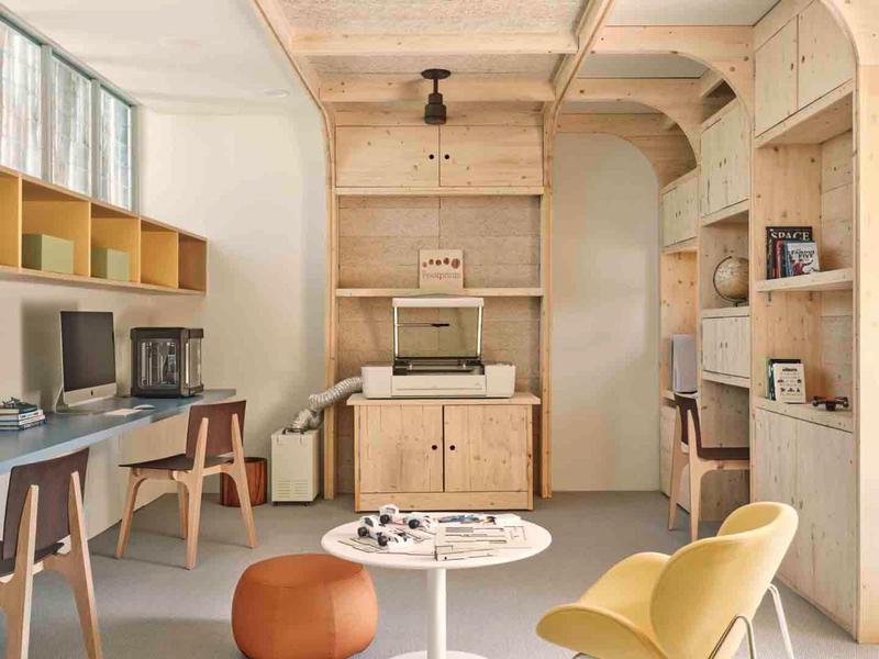 Bright, modern office with wooden furniture, two chairs, and natural light from large windows.