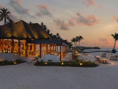 Beachside restaurant with lighting and seating at sunset by the sea