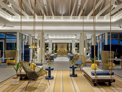 Spacious modern hotel lobby with stylish furniture and bright design at dusk.
