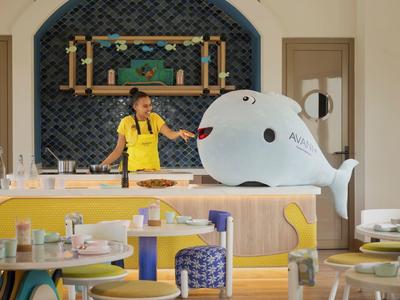 Modern hotel lounge with colorful furniture and large whale decoration.