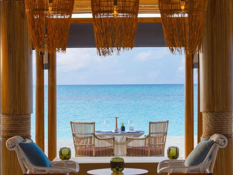 Two chairs and a table with a sea view, bamboo lantern decorations.