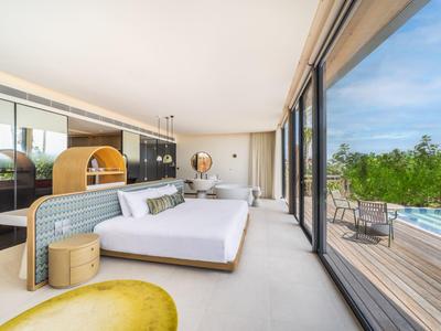 Moderne hotelkamer met grote ramen, tweepersoonsbed en buitenterras met uitzicht op het zwembad.