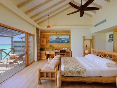 Chambre d'hôtel lumineuse avec meubles en bois et balcon avec vue sur la mer.