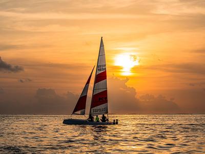 Segelboot auf ruhigem Meer bei Sonnenuntergang.