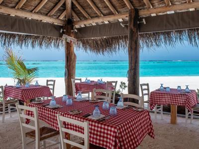 Restaurant en bord de mer avec nappes à carreaux rouges et vue sur l'océan.
