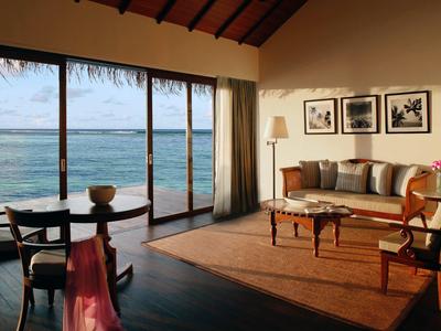 Camera d'albergo accogliente con vista mare, divano e zona salotto al sole.