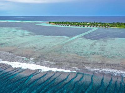 Klares türkisfarbenes Wasser mit einer ruhigen Küste und einer schmalen Landzunge am Horizont.