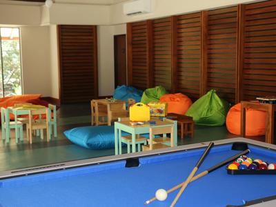 Innenraum mit blauem Billardtisch, bunten Sitzsäcken und kleinen Holztischen mit Stühlen.