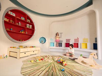 Kinderen spelen in een lichte, moderne kamer met kleurrijk speelgoed en ronde planken.