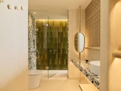 Moderner Hotelbadezimmer mit großer Spiegelwand und Musterfliesen.