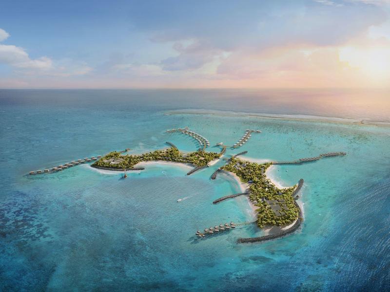 Luchtfoto van een tropisch eiland met stranden, lagune en hotelbungalows boven het water.