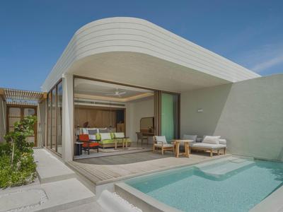 Área de piscina moderna con tumbonas y espacio de vida abierto bajo un cielo despejado.