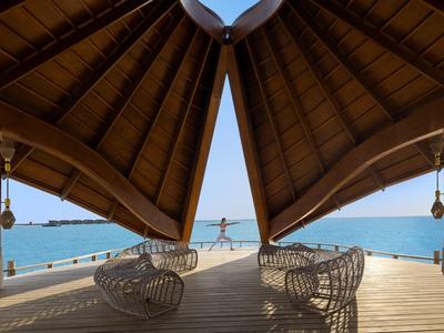 Terraza cubierta con techo de madera y asientos con vista al mar.